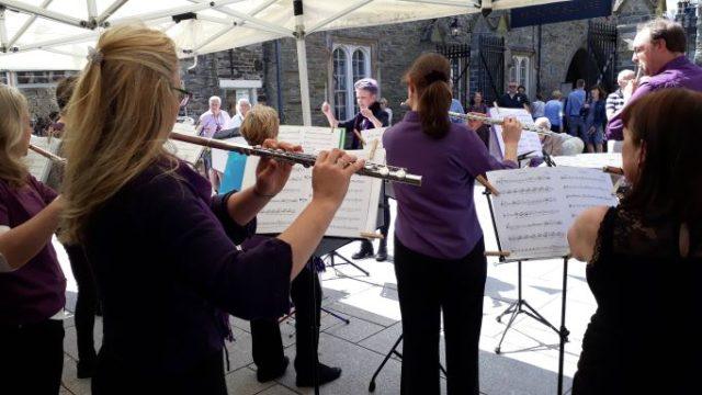 View from the back of members of flute cocktail performing outside the guildhall in tavistock